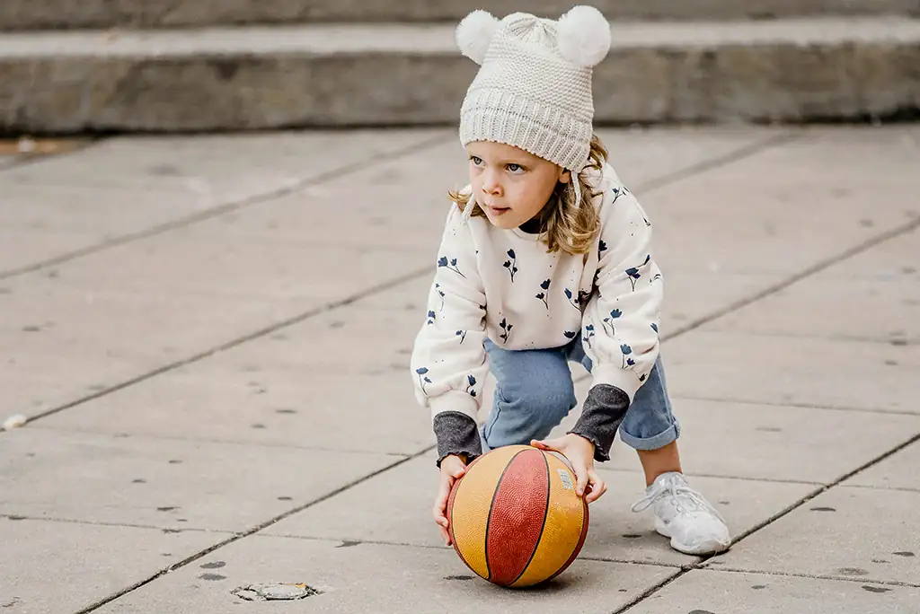 EIn kleines Mädchen legt sich einen Fussball zurecht